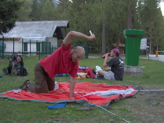 In this image we can see people sitting. There are clothes placed on the grass. On the right there...