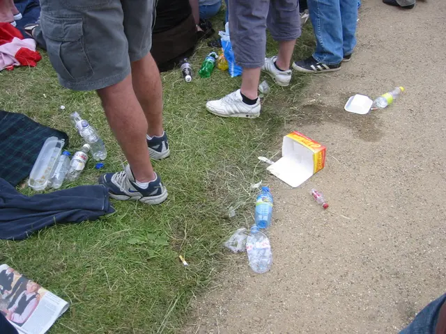 This image is clicked outside. There is grass in this image. There are Water bottles, boxes which...