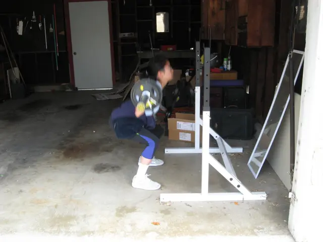 In the picture we can see a gym area where a person is bending and lifting the weight and front of...