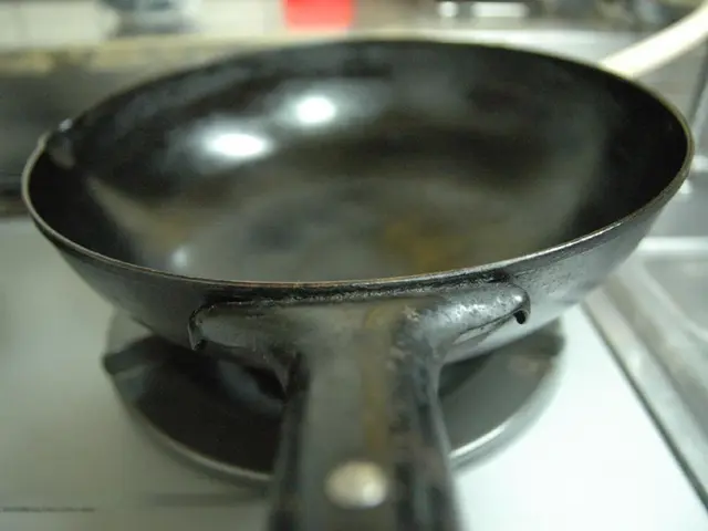 In the image we can see there is a black colour pan kept on the gas stove.