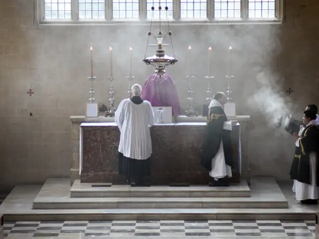 In the center of the image there is a statue and we can see candles placed on the candle holders....