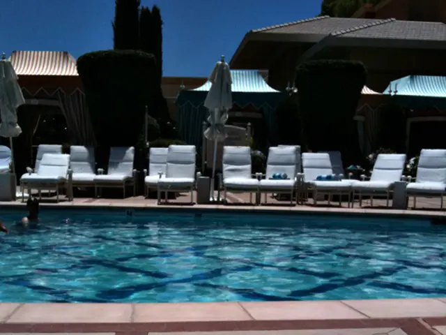 In this image there is some women present on the pool bed. In the background there is swimming pool...