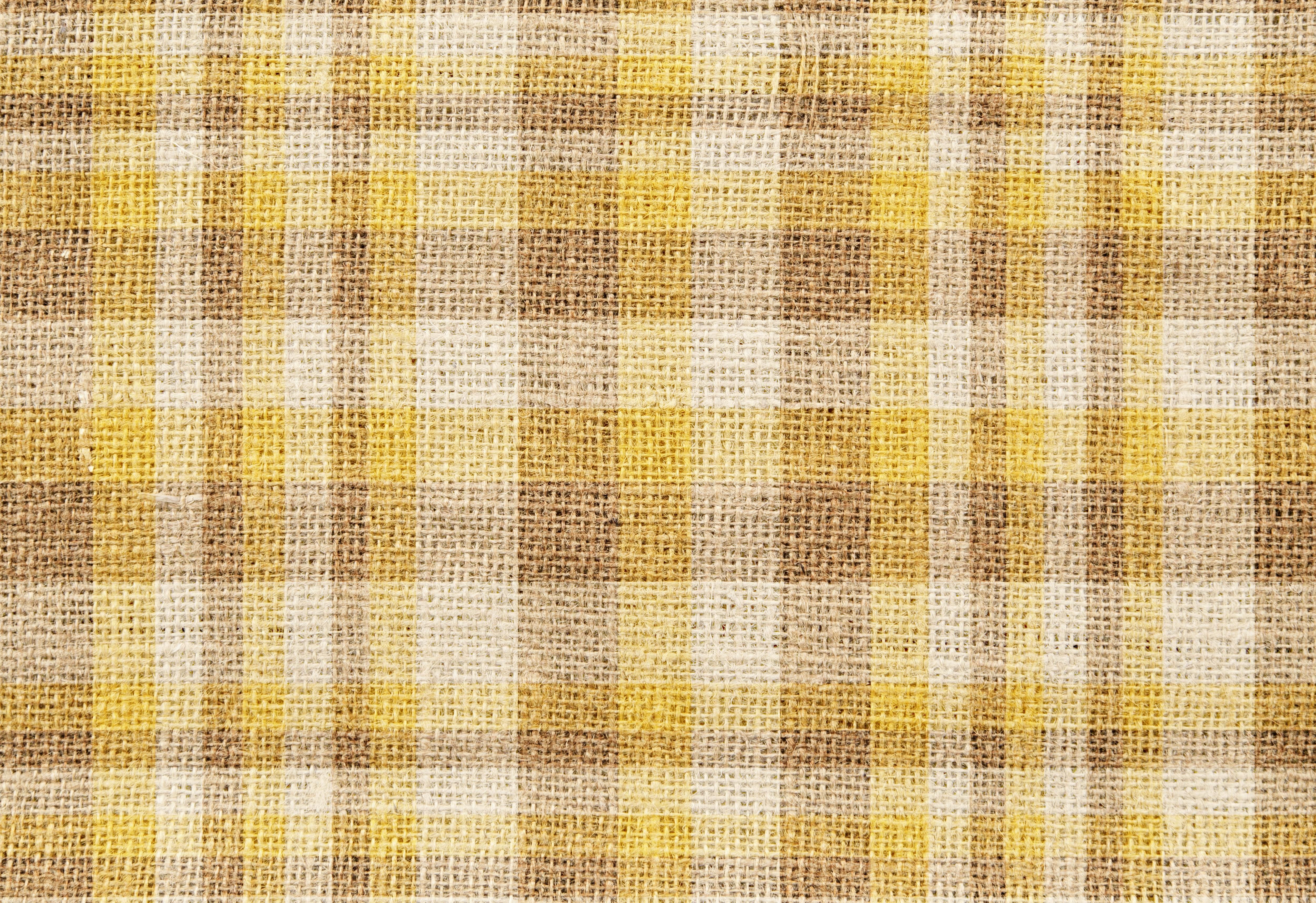 Sunlit yellow room adorned with striped sofa and checkered ottoman. Nineties Home Decor Revivals: 5 Trends We're Happily Re-Experiencing